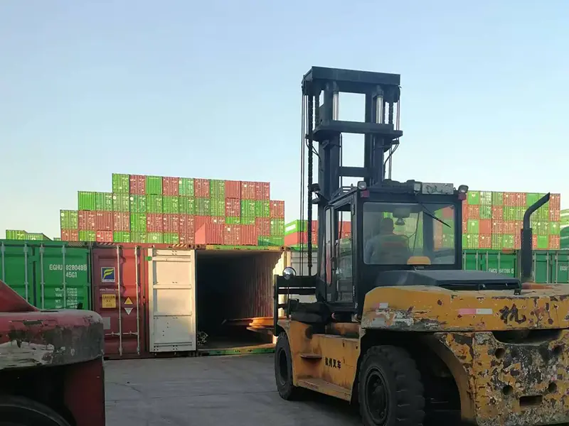 steel rails loaded into container at port for international shipment